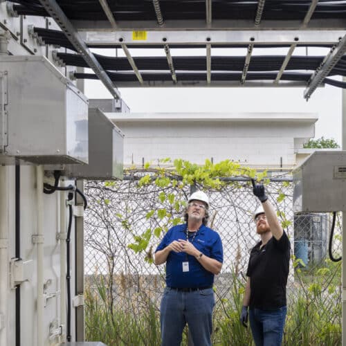 Mark Monroe, a principal infrastructure engineer on Microsoft’s team for datacenter advanced development, and Sean James, Microsoft’s director of datacenter research, stand between the two shipping containers and discuss the three-megawatt hydrogen fuel cell system.